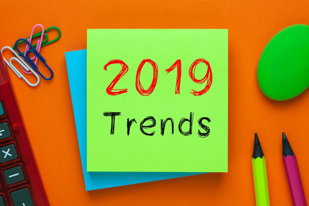 2019 Trends written on green note with pencil and calculator a side.