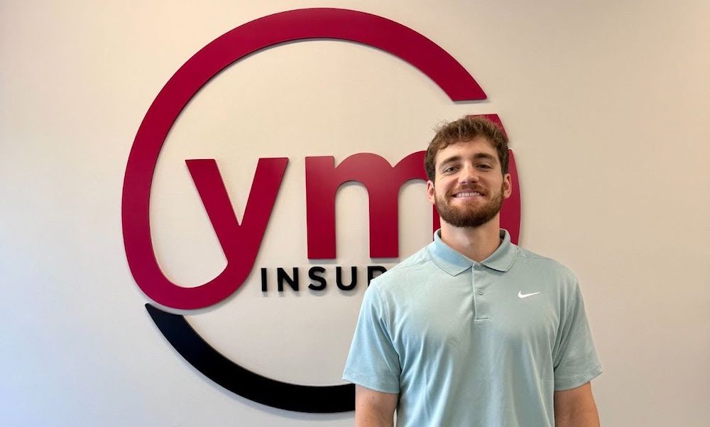 Joseph Galle, YMI’s summer sales intern, standing in front of the YMI Insurance sign at the Allentown office.