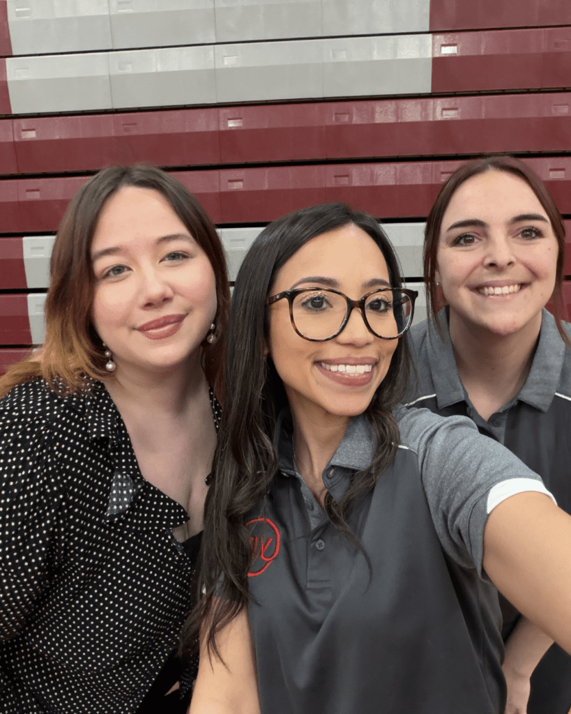 Modesty and Erica with the Pocono Chamber Assistant Manager at Stroudsburg High School’s Career Expo Day, smiling for a selfie in the gym.